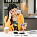 Asian business woman is stressed, bored, and overthinking from working on a tablet at the modern office.