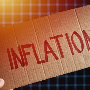 Cardboard with word inflation on background with market exchange rates graph, Stock markets fall due to inflation